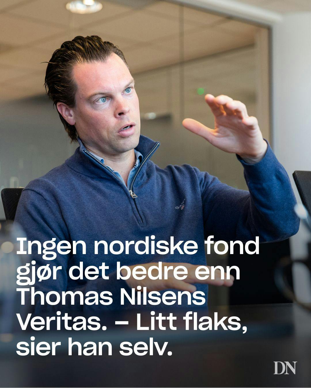 En man i blå tröja som gestikulerar